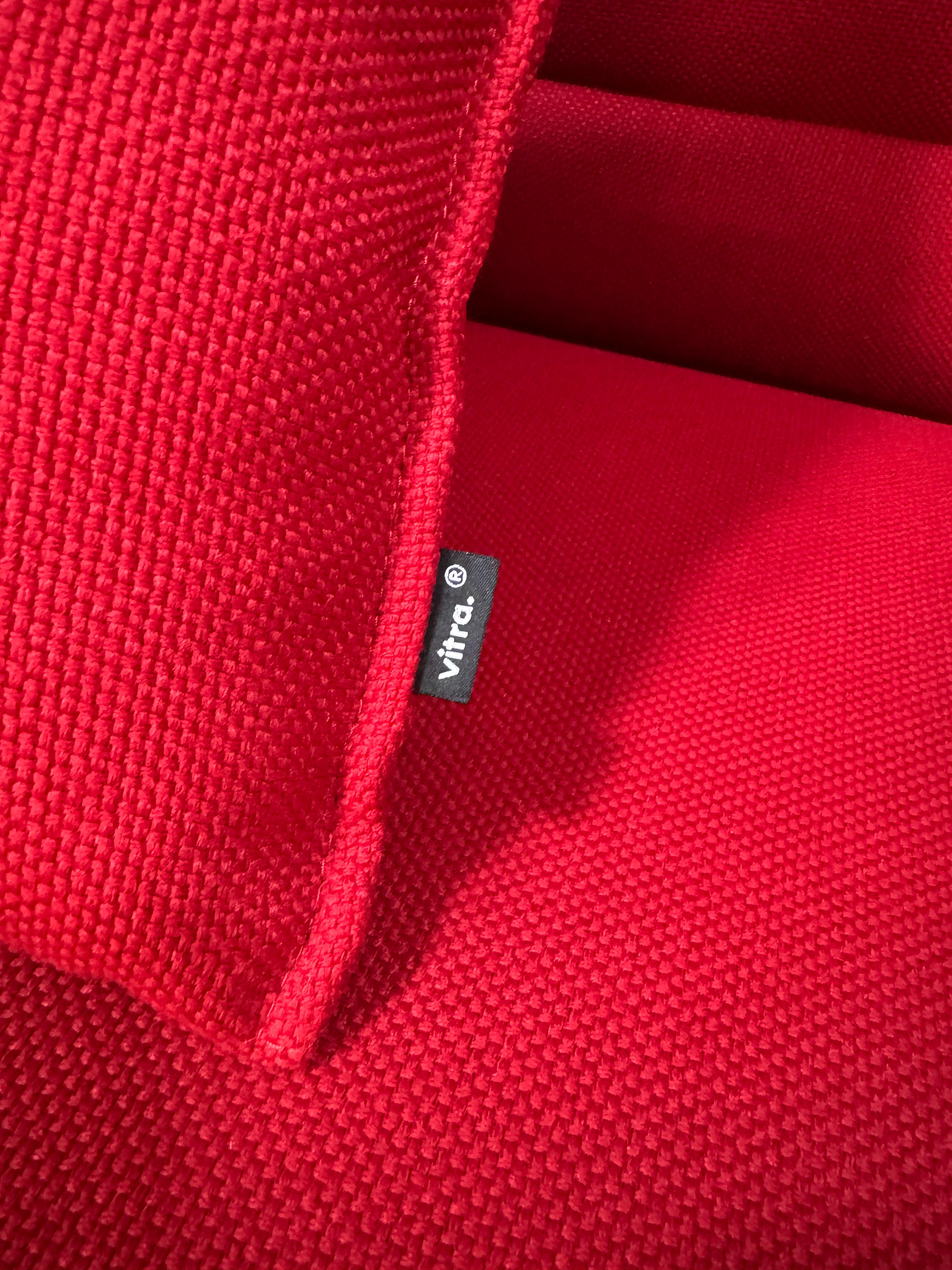 Gebrauchtes rotes Vitra Alcove Designer Stoff Sofa vor einer Wand, stilvoll und modern eingerichtet.