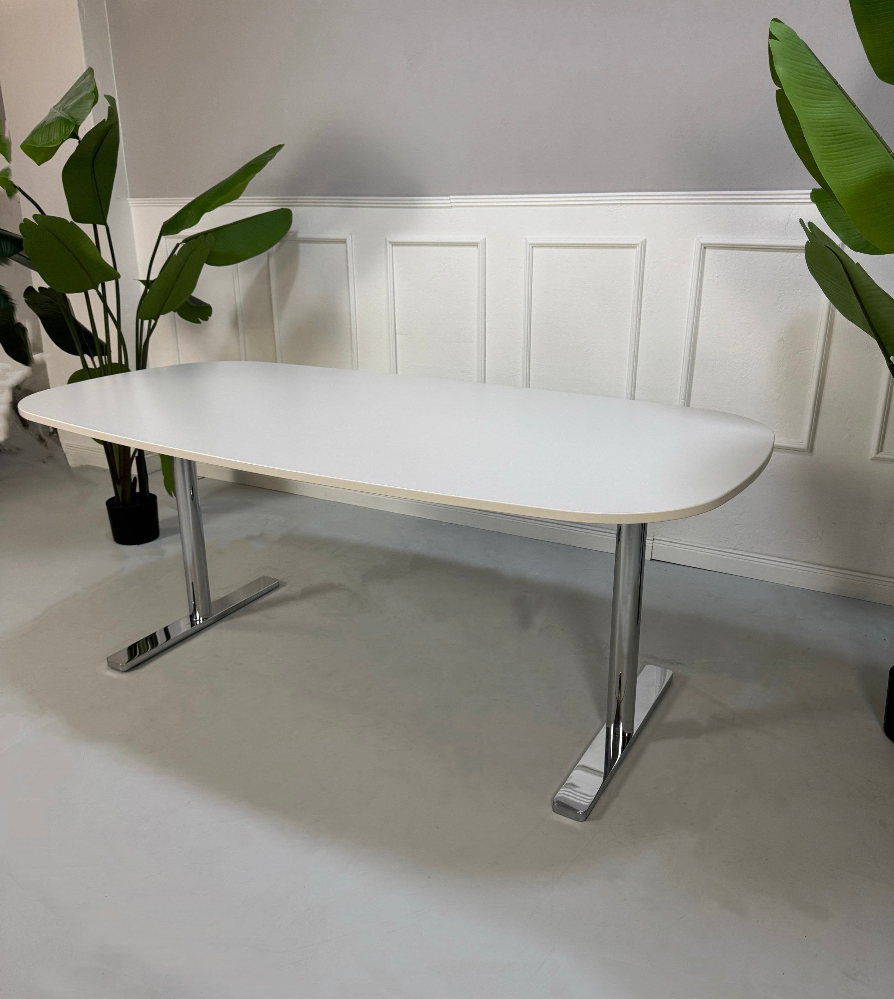 Gebrauchter Vitra Büro Tisch vor einer Wand, stilvoll und modern eingerichtet.