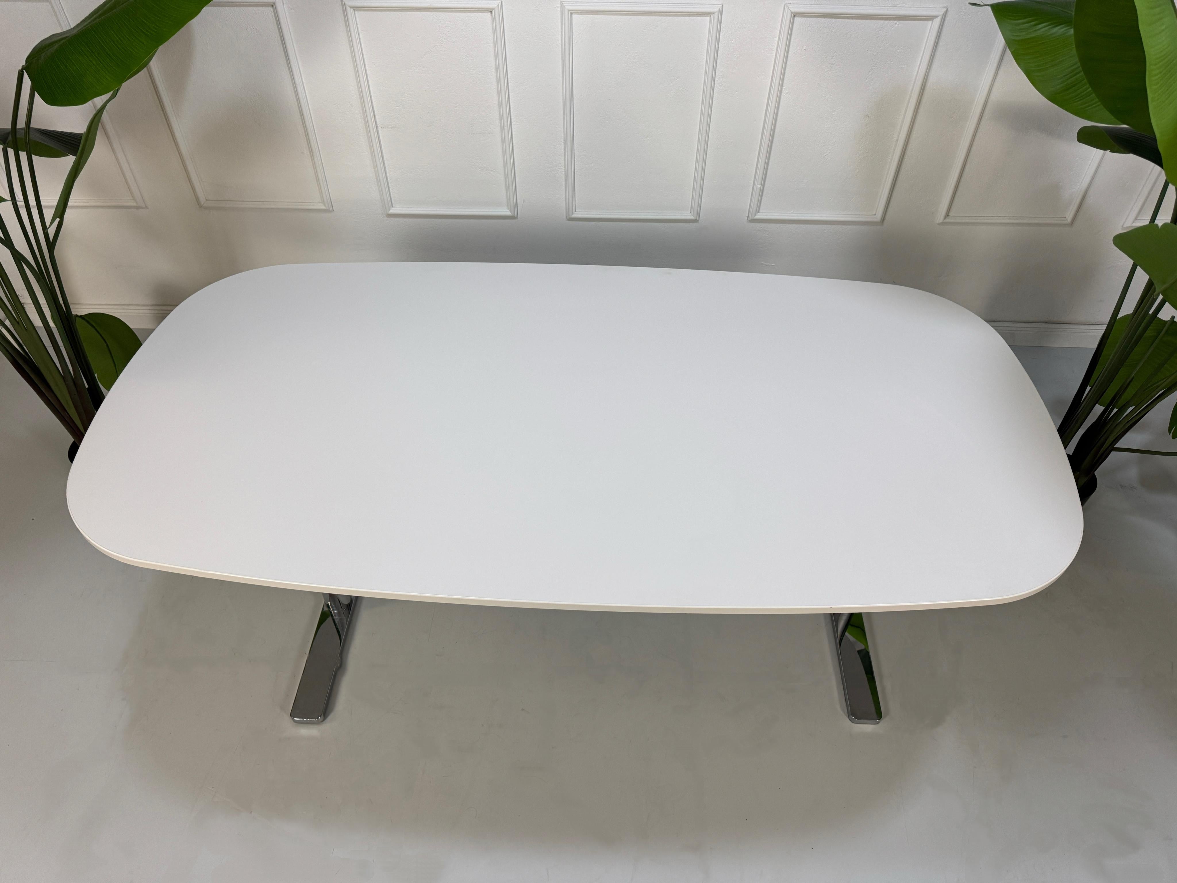 Gebrauchter Vitra Büro Tisch vor einer Wand, stilvoll und modern eingerichtet.