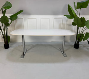 Gebrauchter Vitra Büro Tisch vor einer Wand, stilvoll und modern eingerichtet.