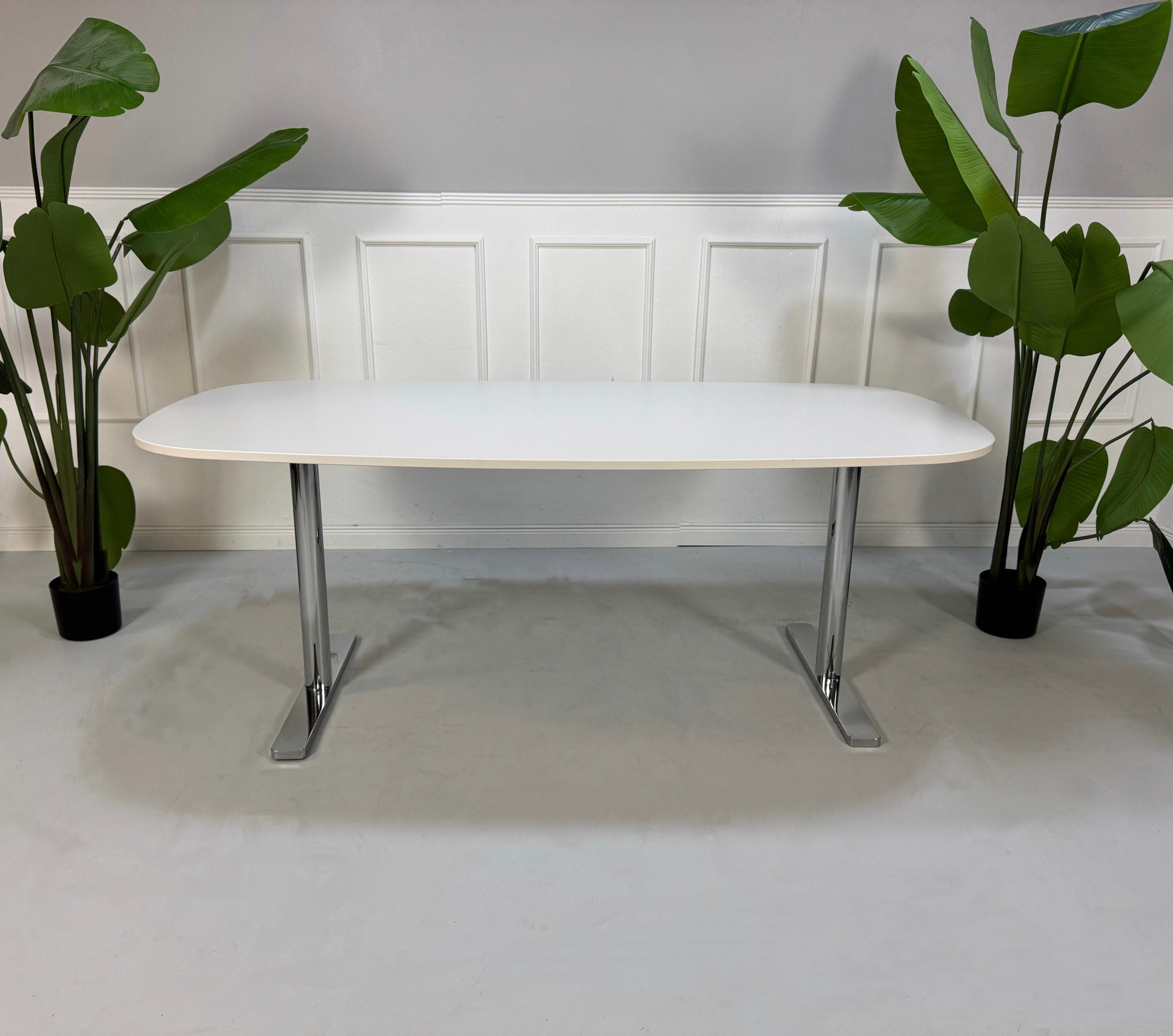 Gebrauchter Vitra Büro Tisch vor einer Wand, stilvoll und modern eingerichtet.