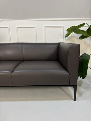 Gebrauchtes braunes Walter Knoll JAAN Designer Leder Sofa vor einer Wand, stilvoll und modern eingerichtet.