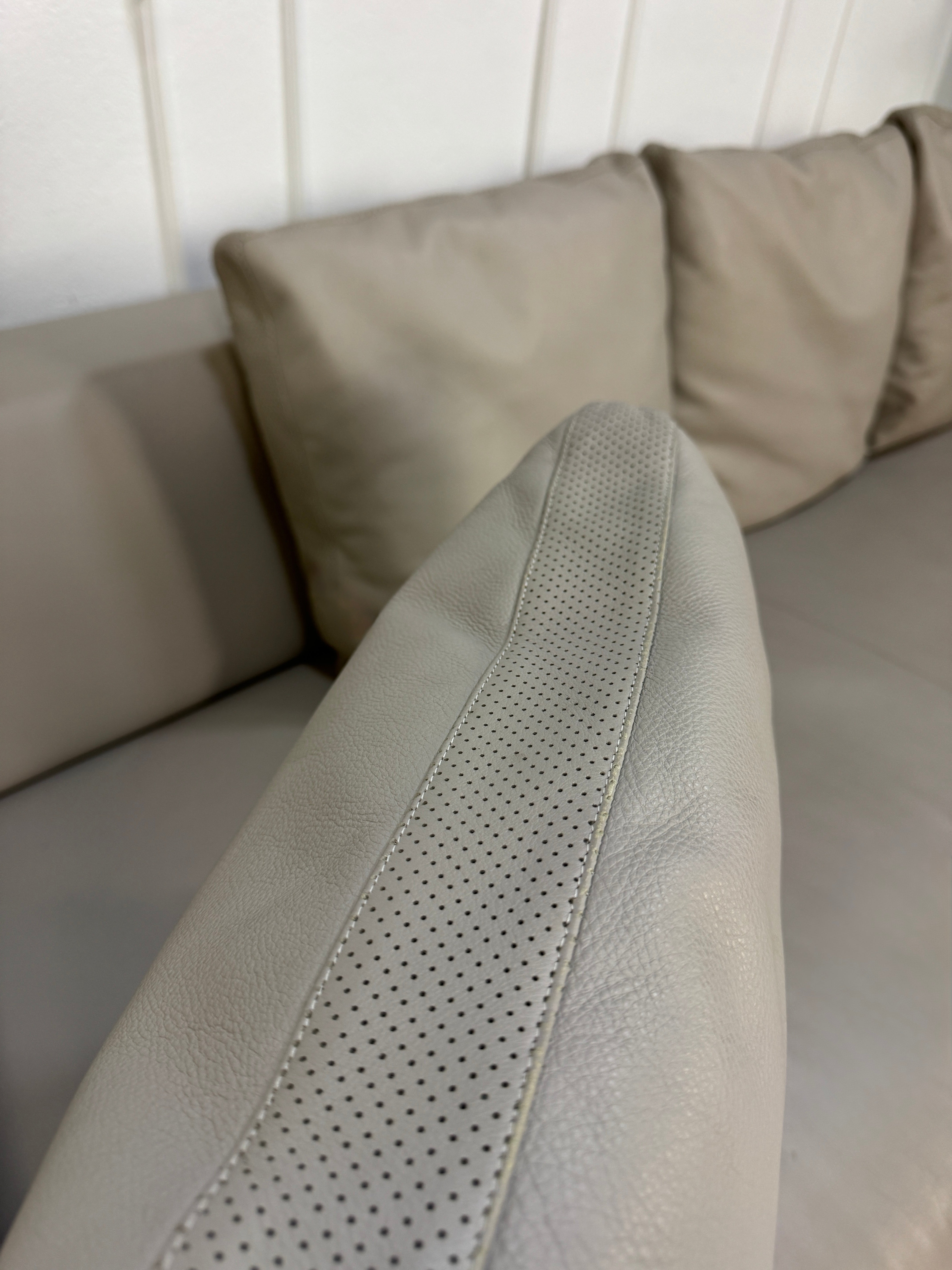 Gebrauchtes graues B&B Italia Solo Designer Leder Sofa vor einer Wand, stilvoll und modern eingerichtet.