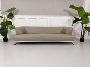 Gebrauchtes graues B&B Italia Solo Designer Leder Sofa vor einer Wand, stilvoll und modern eingerichtet.