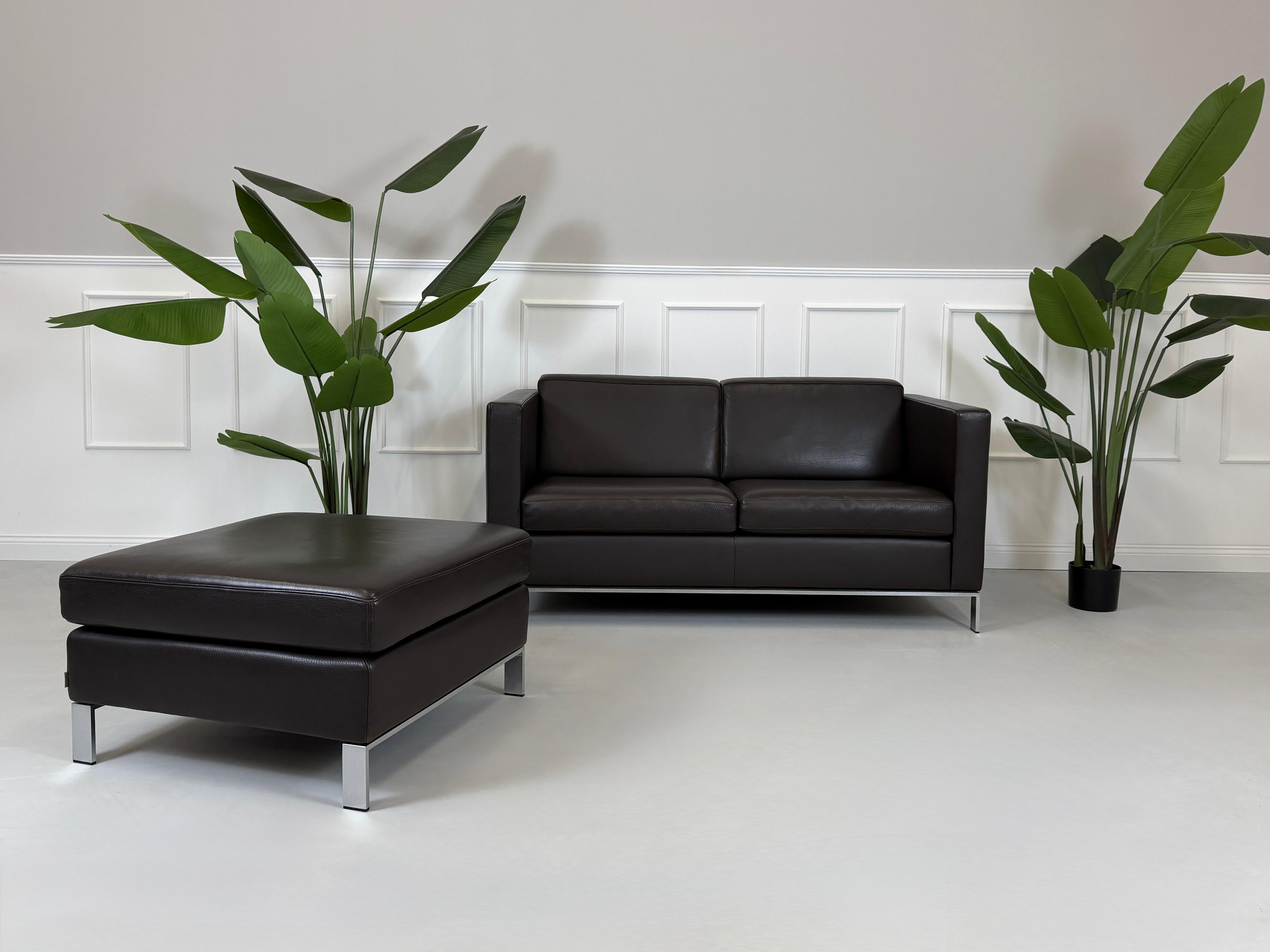 Gebrauchtes braunes Walter Knoll Foster Designer Leder Sofa vor einer Wand, stilvoll und modern eingerichtet.