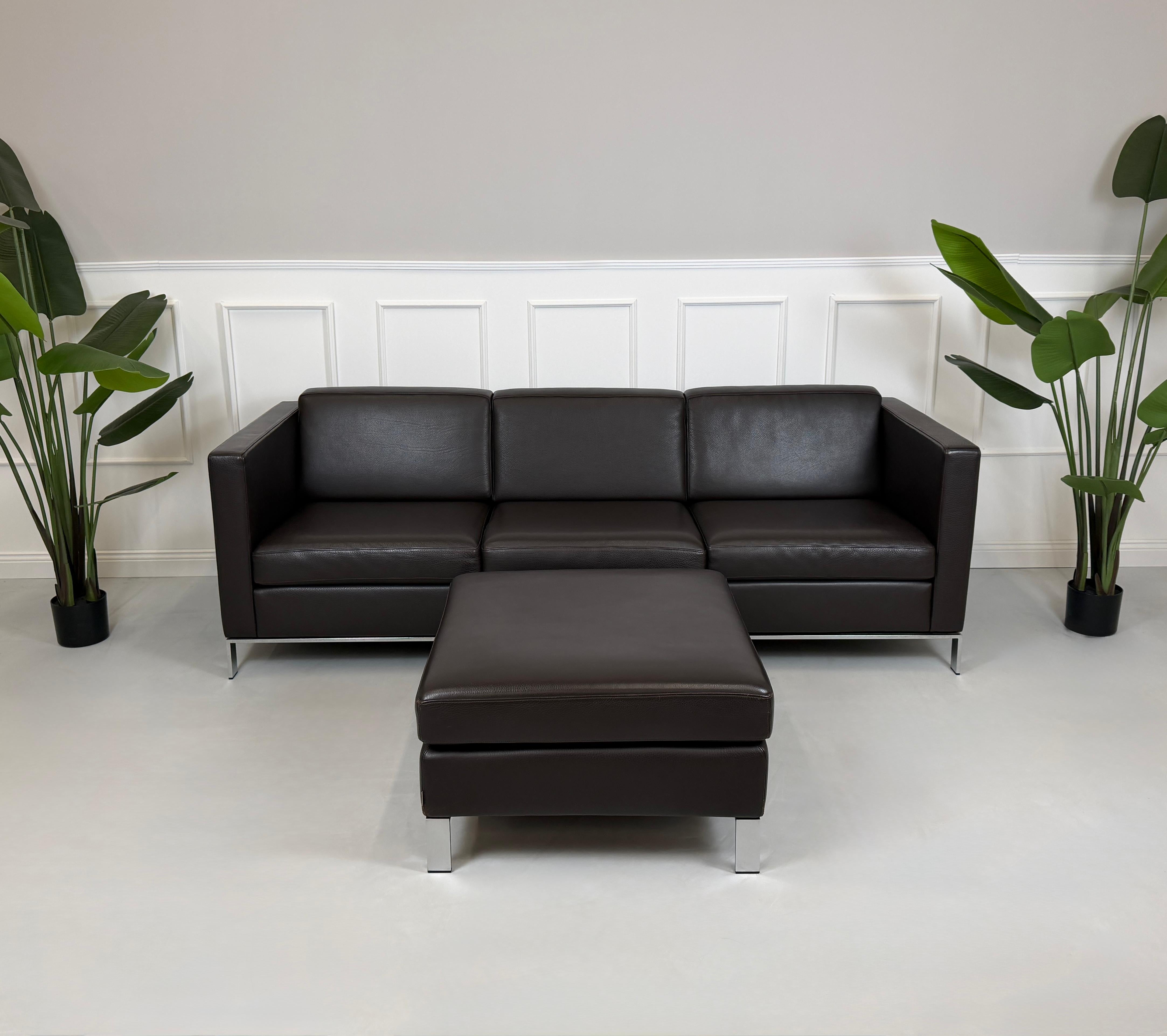 Gebrauchtes braunes Walter Knoll Foster Designer Leder Sofa vor einer Wand, stilvoll und modern eingerichtet.
