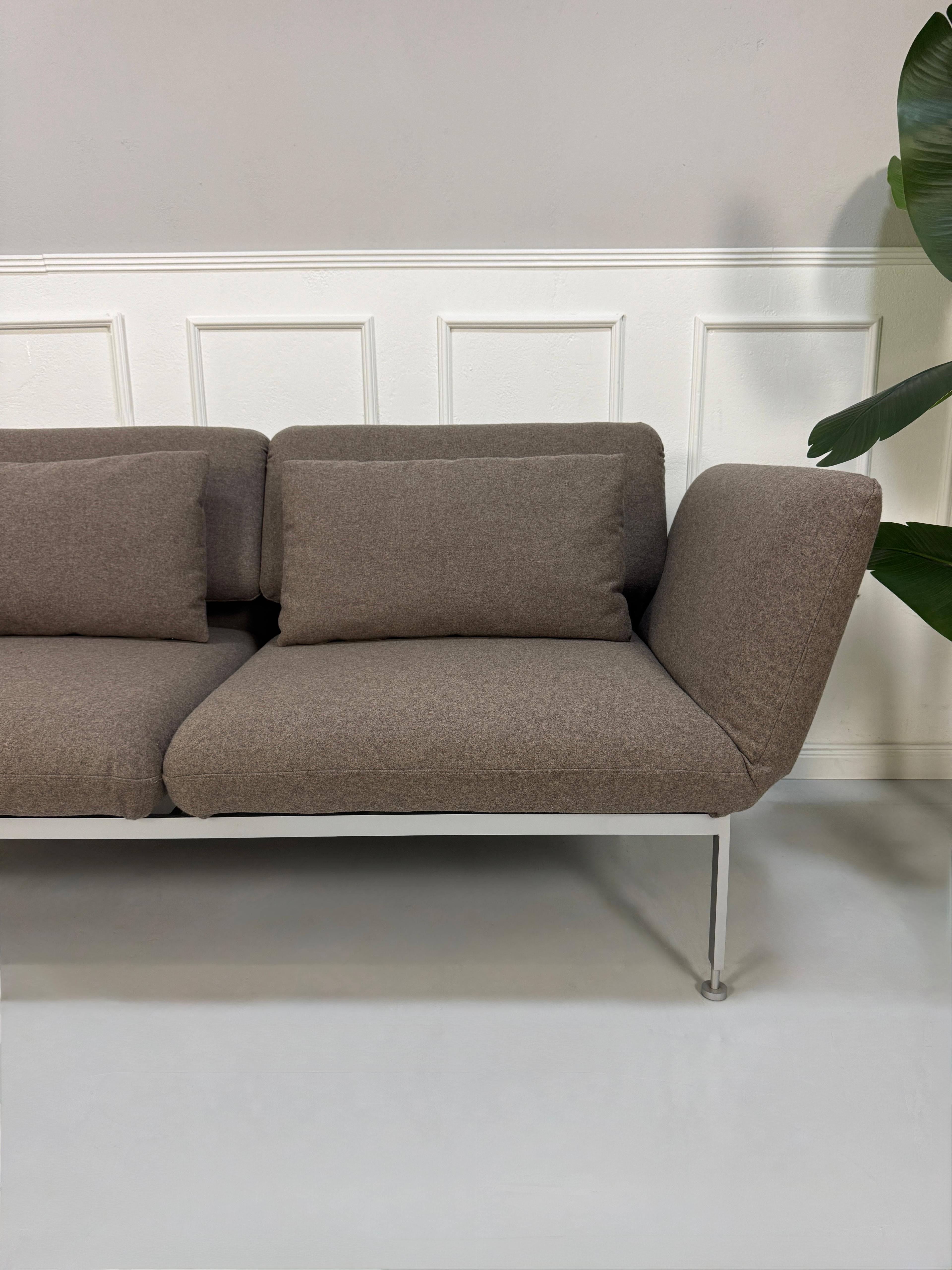 Gebrauchtes braunes Brühl Roro Designer Stoff Sofa vor einer Wand, stilvoll und modern eingerichtet.