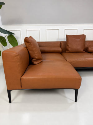 Gebrauchtes braunes Walter Knoll Jaan Living Designer Leder Ecksofa vor einer Wand, stilvoll und modern eingerichtet.