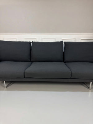 Gebrauchtes graues Cassina Toot Designer Stoff Sofa vor einer Wand, stilvoll und modern eingerichtet.