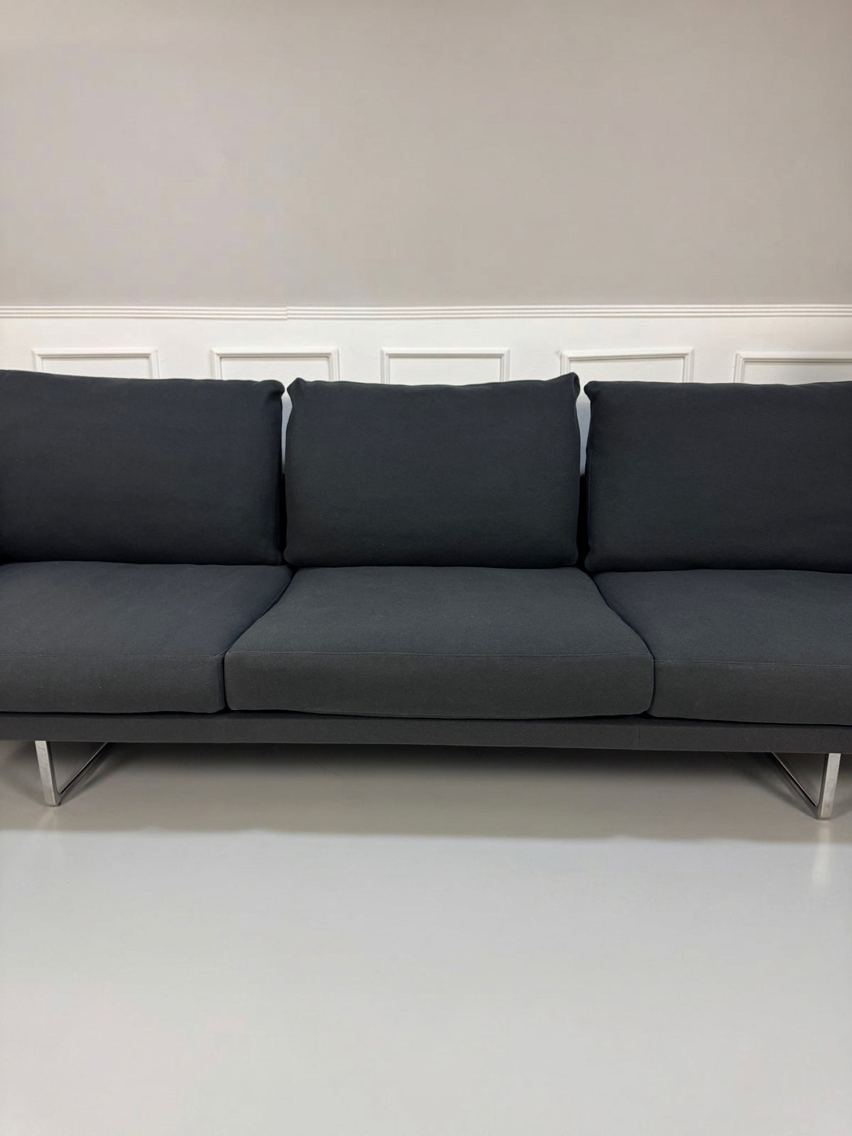 Gebrauchtes graues Cassina Toot Designer Stoff Sofa vor einer Wand, stilvoll und modern eingerichtet.