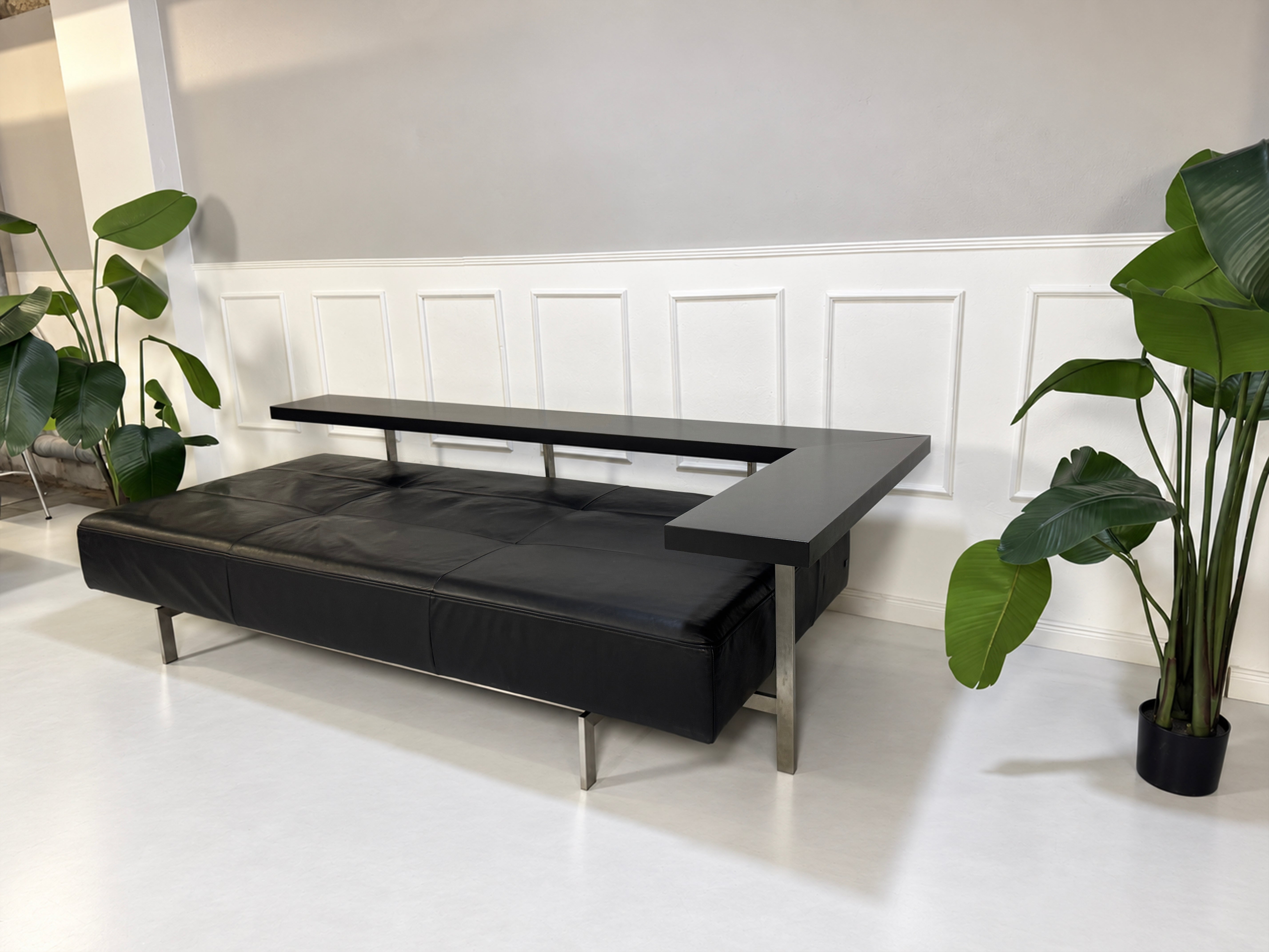 Gebrauchtes schwarzes Rolf Benz Dono Designer Leder Sofa vor einer Wand, stilvoll und modern eingerichtet.