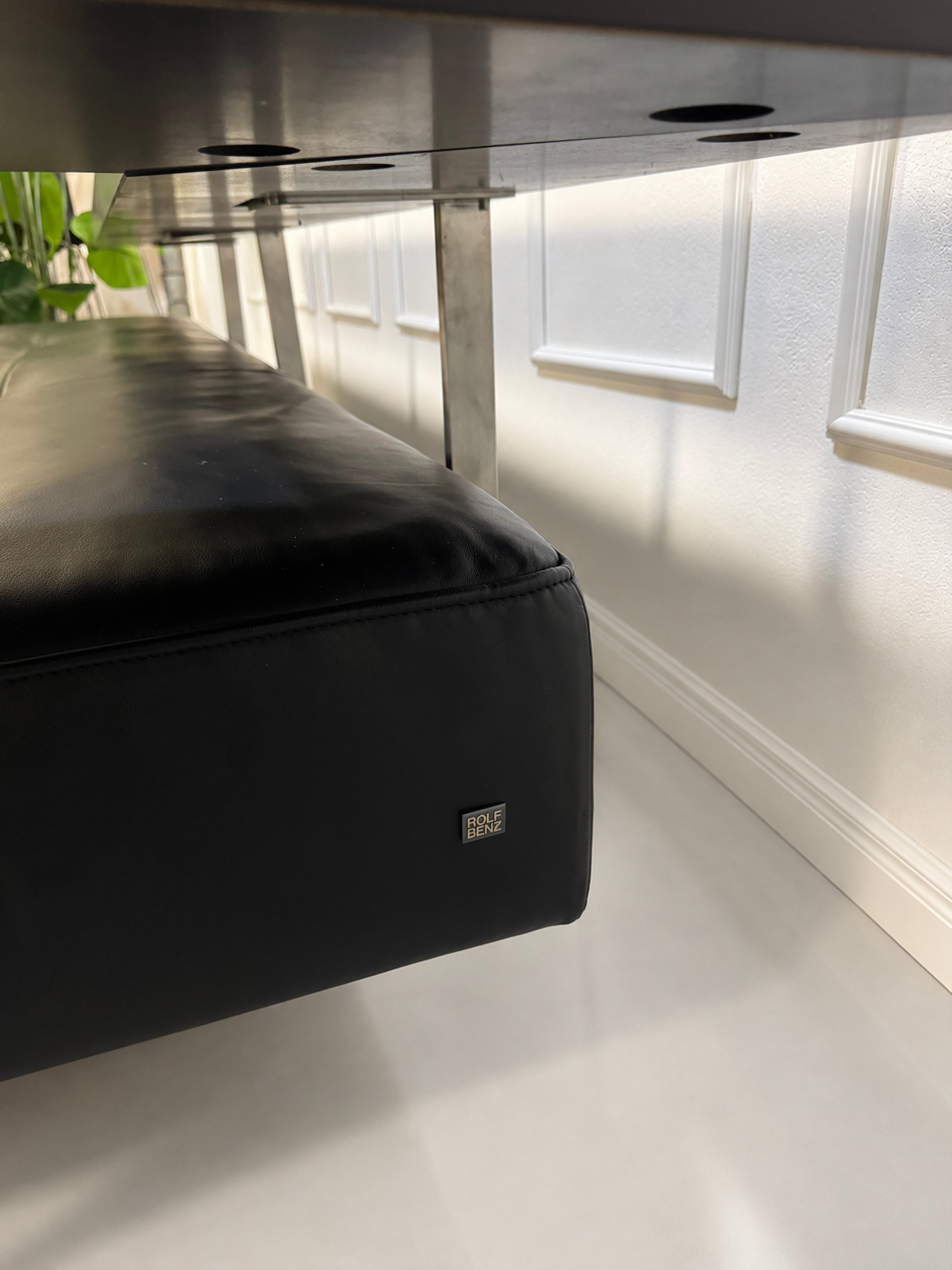 Gebrauchtes schwarzes Rolf Benz Dono Designer Leder Sofa vor einer Wand, stilvoll und modern eingerichtet.