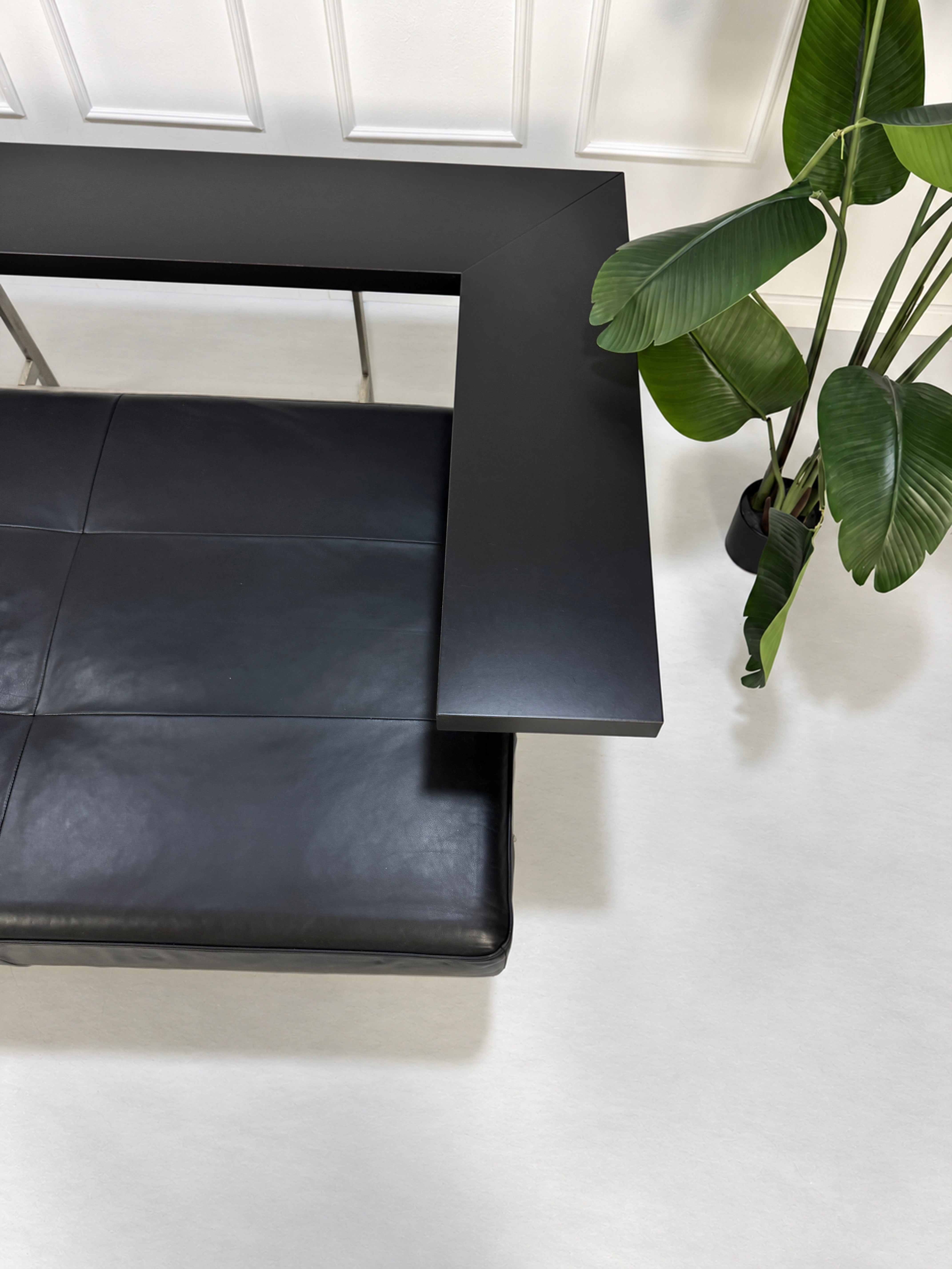 Gebrauchtes schwarzes Rolf Benz Dono Designer Leder Sofa vor einer Wand, stilvoll und modern eingerichtet.