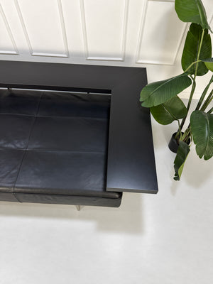 Gebrauchtes schwarzes Rolf Benz Dono Designer Leder Sofa vor einer Wand, stilvoll und modern eingerichtet.